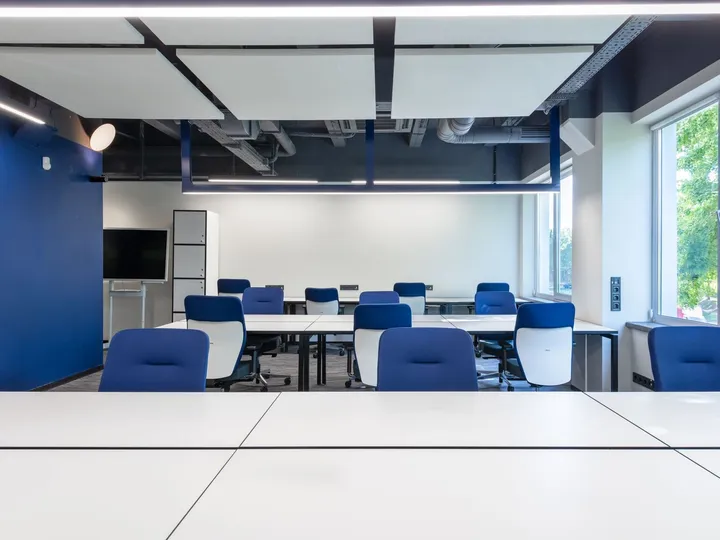 Licht, modern kantoor met werkplekken en blauwe stoelen